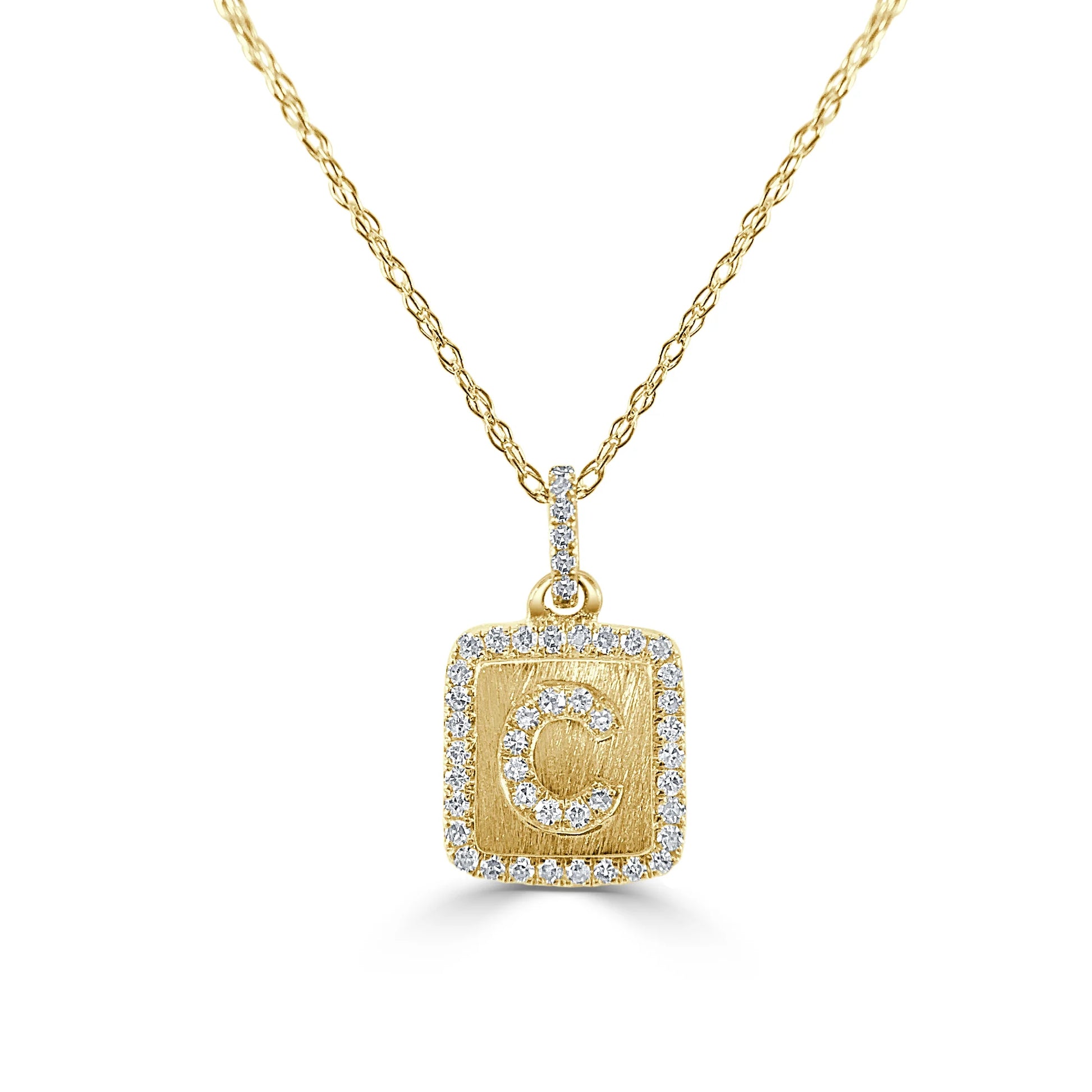 gold and diamond pendant with a letter C