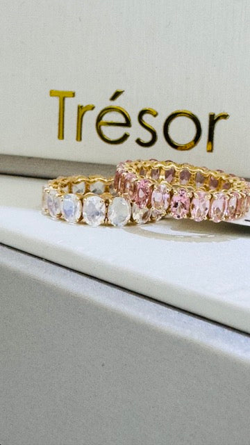 pink gemstone ring next to white gemstone ring