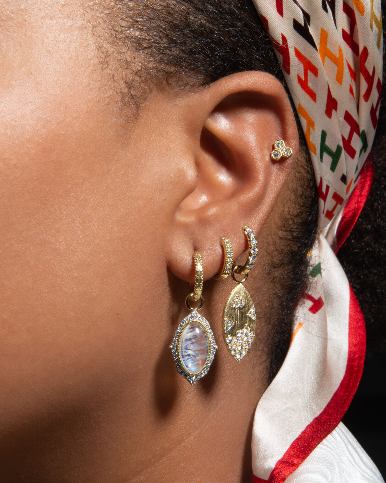 model with multiple gold and diamond earrings