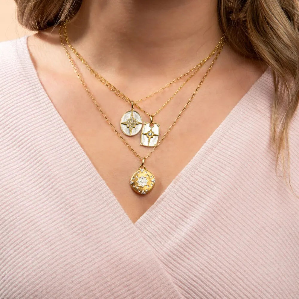 layered necklaces with pendants on woman's neck