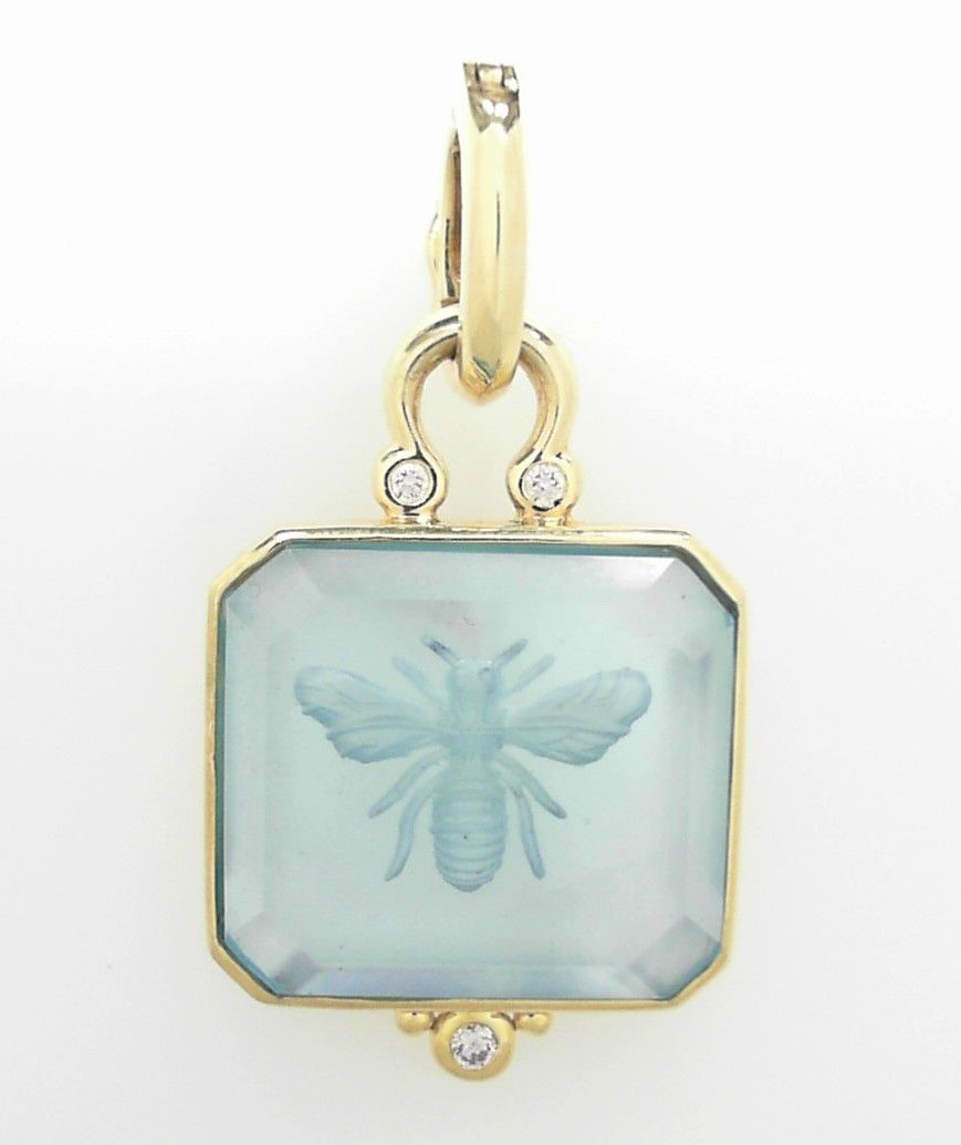 blue pendant with a bee on it