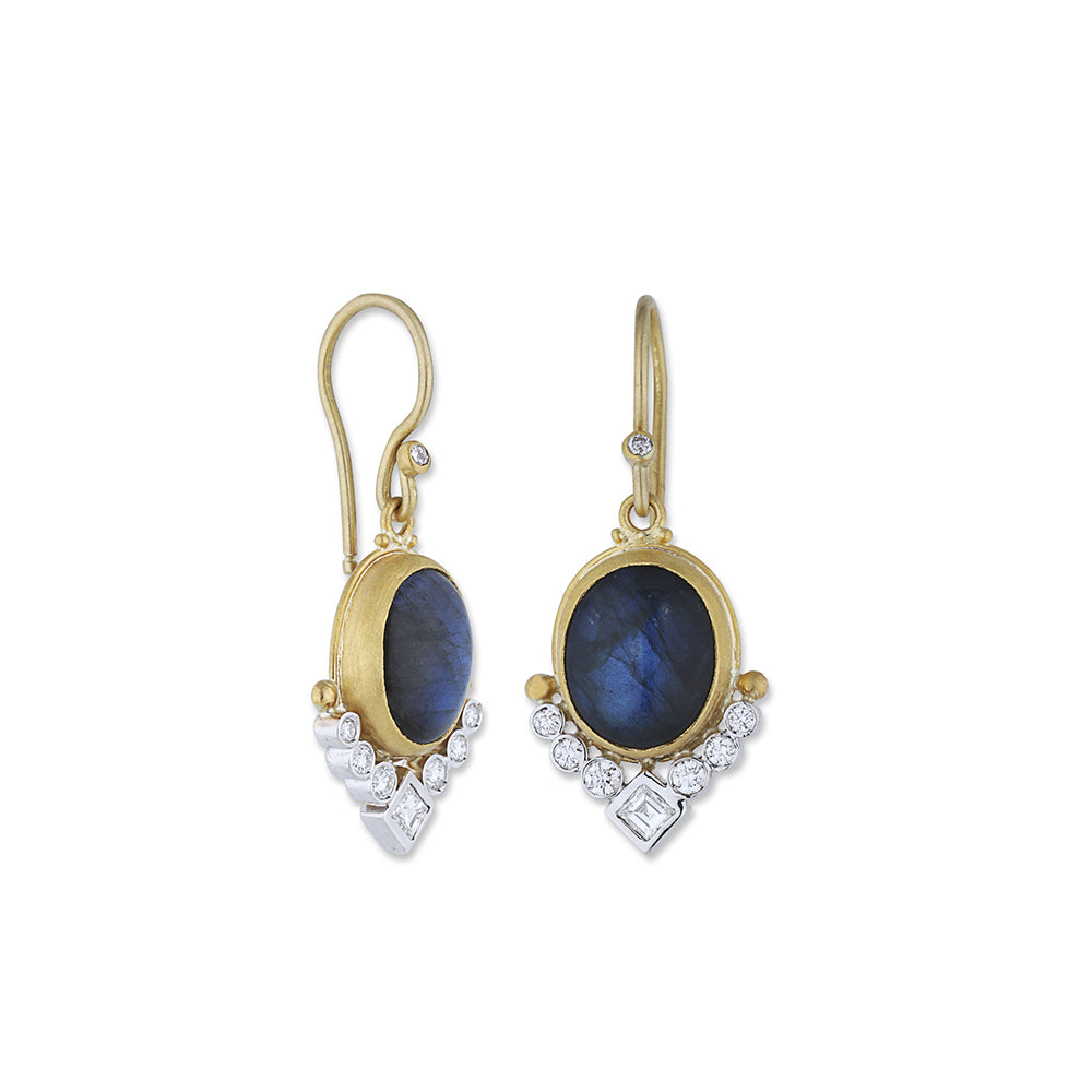 gold earring with a gemstone in the middle and diamonds at the bottom